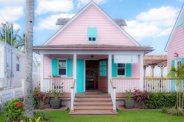 tiny pink Hope Town cottage sports pastel aqua shutters