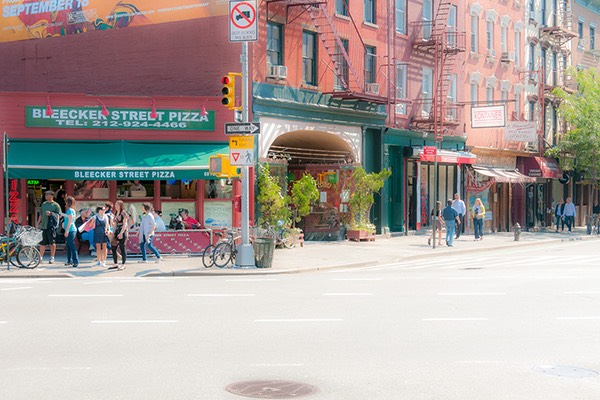 street corner where Bleeker Street peels away from the avenue into Manhattan's Greenwich Village