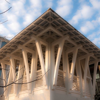 enormous white wood brackets reach up to hold deep sheltering eaves firmly in their embrace against cotton puff-ball clouds set against the blue sky of Rosemary Beach on Florida's Design Coast